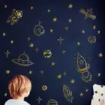 Jeu éducatif sur le thème de l'espace avec fusées, planètes et astronautes en illustration dorée sur fond bleu nuit.