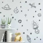 Décoration murale avec dessins d'astronautes, vaisseaux spatiaux et étoiles pour une ambiance cosmique et ludique. Parfait pour une chambre d'enfant ou un espace éducatif sur l'espace.