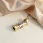Pendentif microscope en métal doré avec chaîne fine, idéal pour les amateurs de science et de décoration originale. Parfait comme bijou ou objet de décoration scientifique.