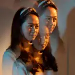 Miroir d'illusion avec femme aux cheveux longs et maquillage naturel, créant un effet visuel intrigant et artistique.