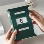 Calendrier en bois vert foncé avec affichage de la date, jour et mois, idéal pour la décoration de bureau ou comme objet scientifique décoratif.