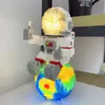 Figurine LEGO d'astronaute avec casque lumineux, sur une planète colorée en LEGO, décor scientifique et ludique.