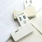 Porte-documents calendrier en plastique blanc avec affichage de la date, idéal pour organiser votre emploi du temps ou décorer un espace de travail avec une touche scientifique.