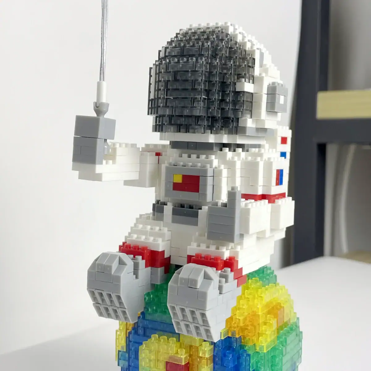Figurine LEGO d'un astronaute assis sur un nuage coloré.