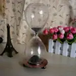 Ampoule en verre avec sable noir à l'intérieur, décoration scientifique élégante.