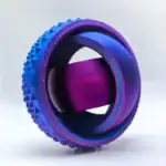Roue dentée en aluminium violet et bleu avec surface texturée pour applications scientifiques ou décoratives.