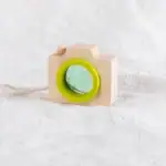 Caméra en bois avec lentille verte, design minimaliste et écologique, idéale comme décoration scientifique ou jouet éducatif pour enfants.