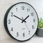Horloge murale moderne à affichage analogique avec chiffres clairs, idéale pour la décoration intérieure et la gestion du temps.