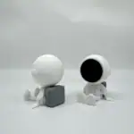 Figurines d'astronautes minimalistes en blanc, assis sur un fond blanc, avec un design épuré et moderne, parfaites pour la décoration scientifique ou thématique.