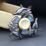 Fidget spinner en métal avec design de dauphins, symboles japonais et détails bleus, idéal pour la décoration ou la détente.