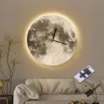 Horloge murale en forme de lune avec éclairage LED, décoration moderne pour salon ou chambre, ambiance cosmique et élégante.