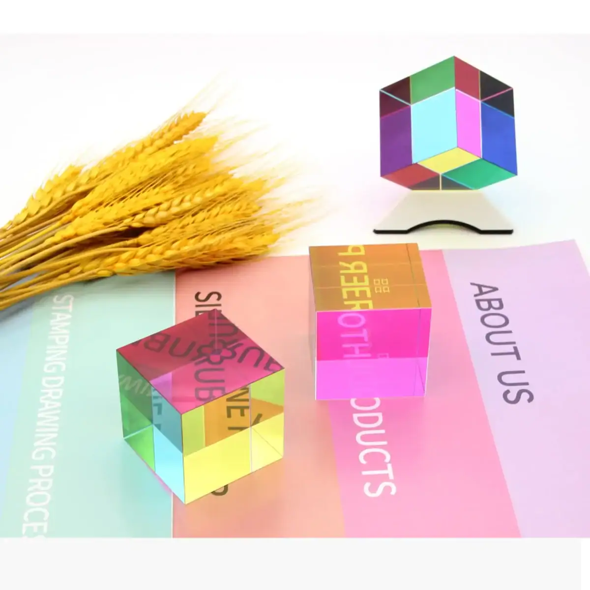 Cube en verre coloré avec motifs géométriques et épis de blé dorés.