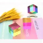 Cube en verre coloré avec motifs géométriques et épis de blé dorés.