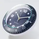 Horloge murale à design scientifique avec cadran noir et chiffres blancs, idéale pour décoration de bureau ou laboratoire.