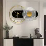 Horloge murale moderne avec éléments géométriques en noir, blanc et or, décoratif et fonctionnel pour un intérieur contemporain.