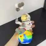 Modèle de vaisseau spatial en briques LEGO avec ballon météorite, exposé dans une main humaine, illustrant une décoration scientifique créative.