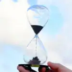 Sablier scientifique en verre avec sable noir, symbole du temps et de la précision, idéal pour la décoration de bureau ou d'espace scientifique.