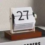 Horloge calendrier vintage en bois et plastique, affichage de la date 27, design rétro pour décoration de bureau ou intérieur.