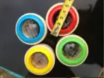Poupées de test optique avec lentilles colorées en rouge, bleu, vert et jaune, utilisées pour des expériences visuelles ou éducatives.