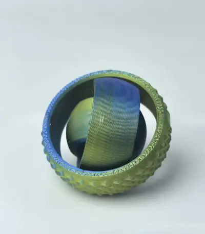 Miniature de globe terrestre insérée dans une balle de tennis, illustrant la fusion entre sport et géographie.