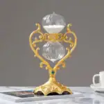 Horloge de bureau vintage en verre avec cadre en or orné de détails floraux et de pierres bleues, élégante et décorative, idéale pour un bureau ou une décoration sophistiquée.