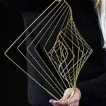 Sculpture décorative en fil métallique doré, forme géométrique moderne pour décoration intérieure ou de bureau.