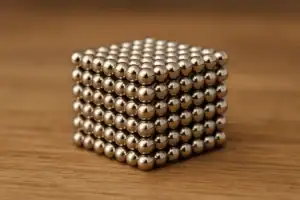 Billes métalliques formant un cube magnétique, idéal pour expériences scientifiques ou décoration moderne.
