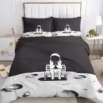 Parure de lit avec design d'astronaute assis sur un banc dans un décor lunaire, idéale pour les amateurs d'astronomie et de décoration thématique spatiale.