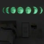 Illustration des différentes phases de la lune en vert phosphorescent, affichées en ligne sur un mur sombre, créant une ambiance mystérieuse et apaisante.