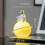 Objet décoratif astronaute et planète lumineuse.