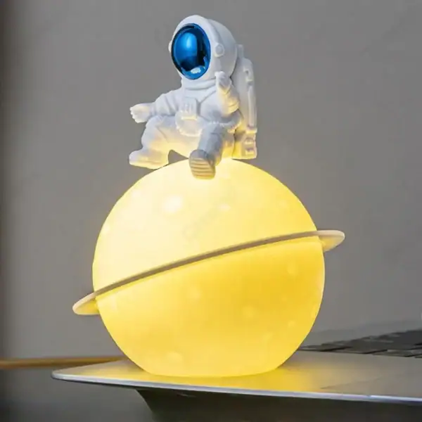 Vêtement d'astronaute avec planète lumineuse et figurine, décoration scientifique originale pour un univers spatial.