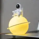 Objet décoratif astronaute sur planète lumineuse.
