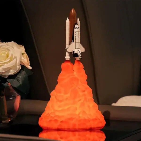 Modèle de fusée en lancement avec nuage de fumée orange, décor scientifique pour collection ou décoration intérieure.