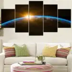 Image de la Terre vue de l'espace avec un lever de soleil brillant à l'horizon, illustrant la beauté de notre planète dans l'univers.