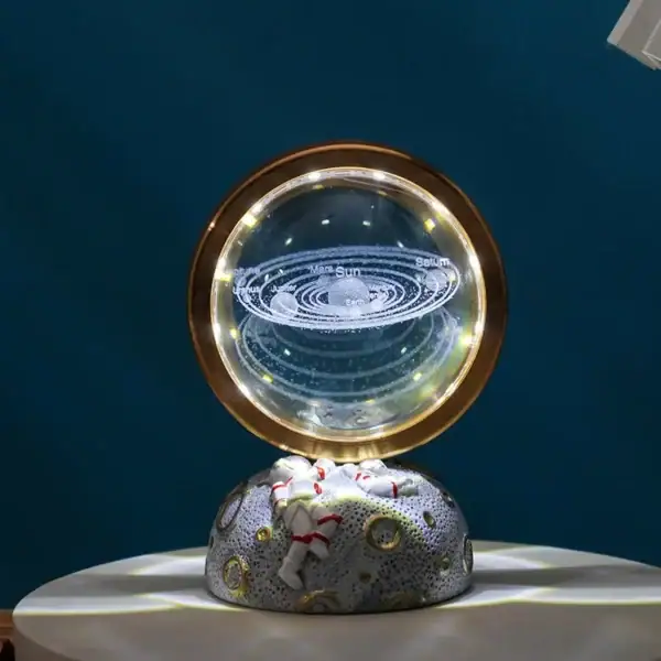 Panneau d'affichage d'un globe terrestre avec des anneaux orbitaux lumineux, représentant le système solaire, posé sur une roche décorative.