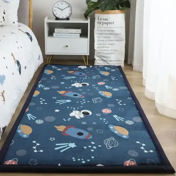 Tapis de jeu pour enfants à thème spatial avec fusées, planètes et étoiles, idéal pour une décoration ludique et éducative dans une chambre ou un espace de jeu.