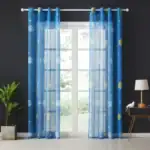 Rideaux en tissu transparent avec motifs planètes, étoiles et lunes dans des tons de bleu et jaune, parfaits pour une décoration thématique scientifique ou pour une chambre d’enfant.