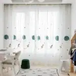 Balcon avec rideaux décorés de planètes et fusées pour chambre d'enfant.