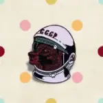 Casque d'astronaute soviétique avec un visage de loup rouge, symbole de l'exploration spatiale et de la science soviétique, présenté dans une boutique d'objets scientifiques.