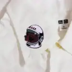 Patch d'astronaute avec visage soviétique sur un vêtement blanc, symbole de l'exploration spatiale et de l'histoire soviétique.
