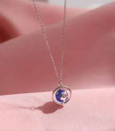 Collier avec pendentif globe terrestre miniature en argent, symbole de voyage et de découverte.