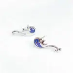 Boucles d'oreilles en forme de sirène en argent avec détails en bleu marine, parfaites pour les amateurs de bijoux inspirés de la mer et de la science.