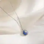 Collier délicat avec pendentif planÚte Terre en verre bleu et argent.