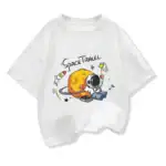 T-shirt blanc avec illustration d'un astronaute et d'une planète, thème spatial, style cartoon, idéal pour les amateurs de science et d'espace.