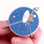 Montre décorative en forme de satellite avec cadran bleu et détails métalliques.