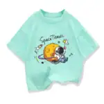 T-shirt pour enfant avec design de planète, astronaute et fusée dans un style ludique et coloré. Parfait pour les amateurs d'espace et de science.