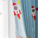 Rideau enfant avec motif fusée rouge et étoiles jaunes, décoratif pour chambre d'enfant ou espace ludique. Facile à fixer et à entretenir, apportant une touche spatiale à la décoration.