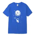 T-shirt bleu avec illustration d'un astronaute suspendu à la lune, entouré d'étoiles, avec le mot "Hello" écrit à côté. Design ludique et scientifique pour les amateurs d'espace.