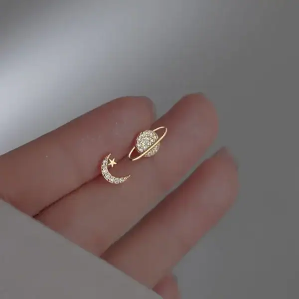 Bijou d'oreille en forme de lune et d'étoile ornée de diamants, symbolisant la celestialité et l'élégance.