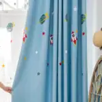 Rideau à thème spatial avec planètes, étoiles et fusées pour décoration de chambre d'enfant.